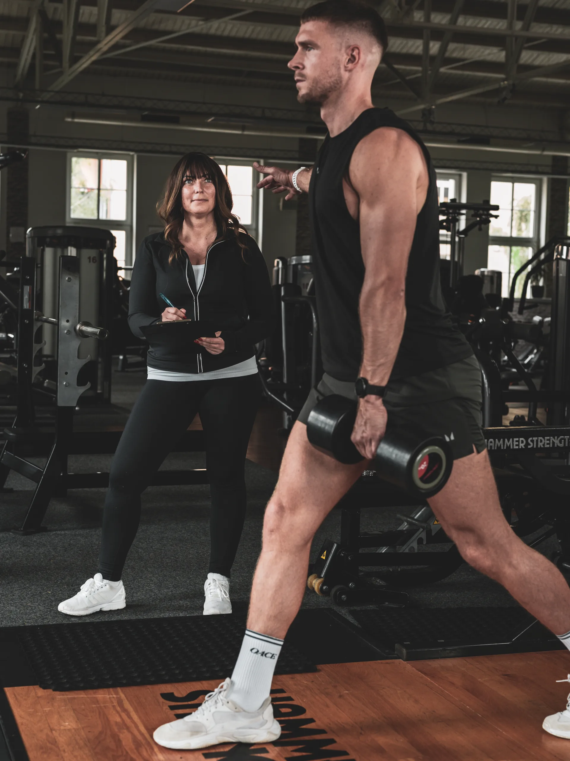 Liane begleitet einen Sportler beim Krafttraining